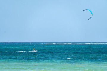 man is kitesurfing in the Caribbean sea.