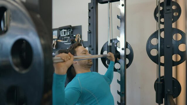 European Guy Doing Seated Barbell Shoulder Press in Smith Machine, Exercise Used To Build Shoulder Strength And Muscle. Medium Close-up Shot