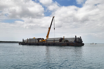 Construction Steel Pipe Pile used Piling Barge for driven pile and construction site workers. barge carries construction piles for the construction of the bridge.