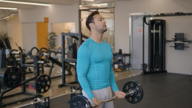 Fit French Man Doing Barbell Bicep Curls, Building A Bigger Biceps Brachii Muscle As Well As The Brachialis. Slow Motion Shot
