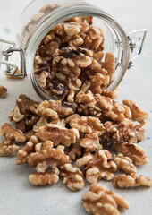 Raw healthy organic walnut nuts snack in glass jar on white kitchen table.Macro.
