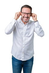 Handsome middle age elegant senior business man wearing glasses over isolated background Smiling pulling ears with fingers, funny gesture. Audition problem