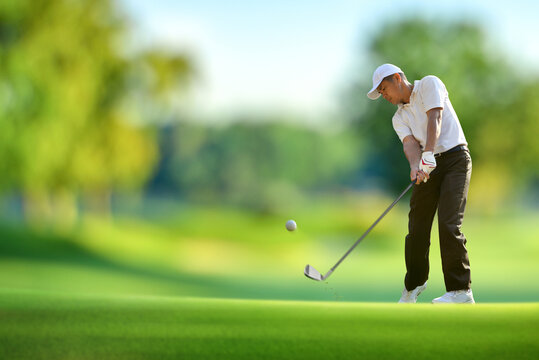 Golfer weight shift goft ball on fairway.