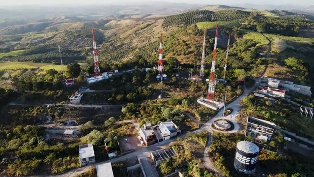 Radio and telecommunication antennas on hill surrounded by crop fields. Tepic, Nayarit