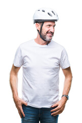 Middle age senior hoary cyclist man wearing bike safety helment isolated background looking away to...