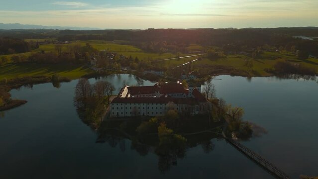 Famous Kloster Seeon monastery in Bavaria, Germany. Church on lake island. Scenic alps mountains