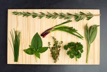 Basil, thyme, and rosemary on chopping block for nutrition, health and adding flavour to food....