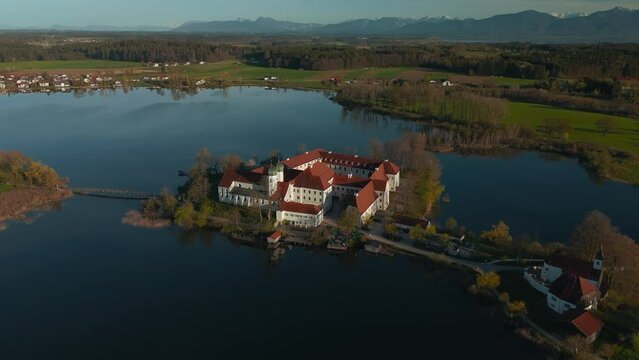 Kloster Seeon, Bavaria. Catholic monastery church on lake island. Scenic alps mountains aerial Germany