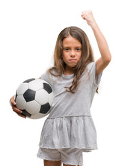 Brunette hispanic girl holding soccer football ball annoyed and frustrated shouting with anger,...
