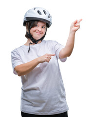 Young adult cyclist woman with down syndrome wearing safety helmet over isolated background smiling and looking at the camera pointing with two hands and fingers to the side.