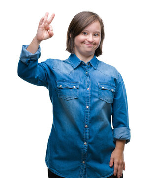 Young adult woman with down syndrome over isolated background smiling positive doing ok sign with hand and fingers. Successful expression.