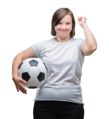 Young adult woman with down syndrome holding soccer football ball over isolated background screaming proud and celebrating victory and success very excited, cheering emotion