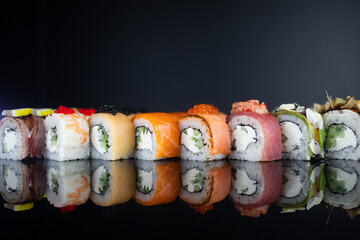 rolls with salmon tuna avocado eel beautifully decorated with lemon caviar on a dark background...