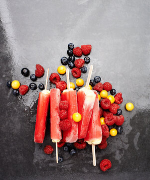 Berries, popsicle or ice lollies for eating strawberry flavor dessert for sweet delicacy in restaurant. Raspberry, background or top view of a delicious frozen snack or cold tasty treat with fruits