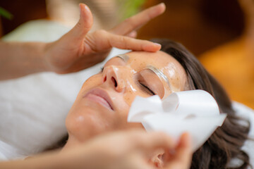 Woman indulges in a luxurious skincare treatment with a face mask at the beauty salon - 781825908
