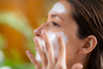 Self care moment as a woman applies a nourishing face mask in the comfort of her home - 781826104