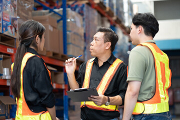 Male and female warehouse workers working and standing talking together at the storage warehouse....