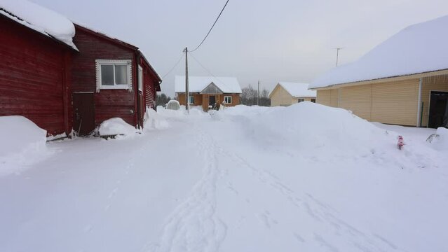 Clearing snow from lot on adjacent property using hand tools.