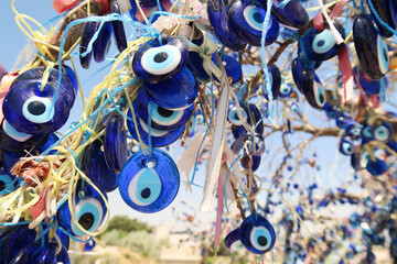 Close up on the blue glass eyes hanging from the evil eye tree next to the Pigeon Valley,...