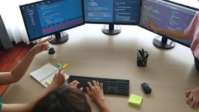 Slow motion back end software developer engineer for computer programming working together on debugging writing computing code, solving complex algorithms display on monitor in office. Burgeoning