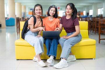 full body photo Group of 3 Asian female college students studying online with laptops, researching...