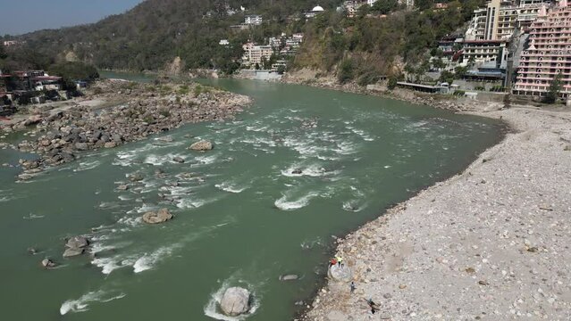 Drone shot of Rishikesh City. Aerial view of the beautiful holy river Ganga, Lakshman Jhula bridge, and Tera Manzil Temple, Trimbakeshwar in Rishikesh. 