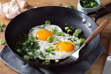 Fried eggs with vegetables on pan - 781851520