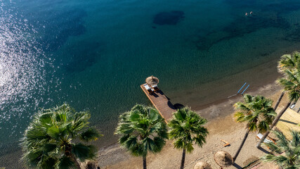 Beautiful luxury umbrella and chair around sea on pier  hotel and resort with coconut palm tree on blue sky