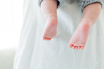 Mother holding baby feet while asleep