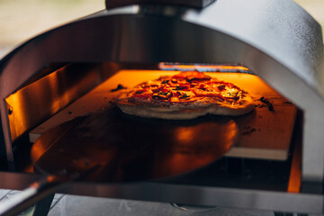 Pizza cooking in an outdoor pizza oven