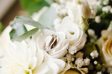 Bokeh on silver wedding ring between white flowers
