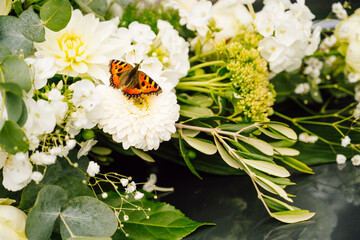 Orange butterfly of white and green wedding bouquet