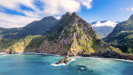 The majestic green mountains of Madeira rising above the crystal-clear, azure ocean; the natural...