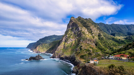 The majestic green mountains of Madeira rising above the crystal-clear, azure ocean; the natural...
