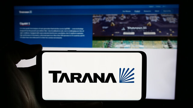Stuttgart, Germany - 03-28-2024: Person holding cellphone with logo of US telecommunications company Tarana Wireless Inc. in front of business webpage. Focus on phone display.