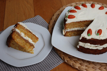 Sliced homemade carrot cake with mascarpone cream cheese icing and mini marzipan carrot decorations