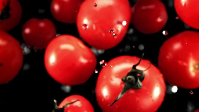 A display of vibrant red tomatoes, a seedless fruit, on a dark background. These natural foods are a popular ingredient in various dishes and are packed with nutrients, making them a superfood