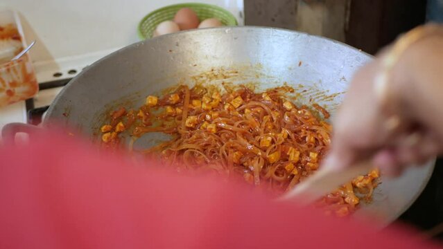 POV while cooking fry Pad Thai in kitchen. Famous street food of thailand