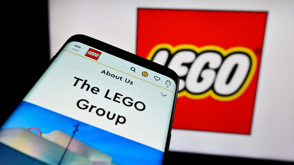 Fototapeta premium Stuttgart, Germany - 04-02-2024: Smartphone with website of Danish construction toy company LEGO AS in front of business logo. Focus on top-left of phone display.