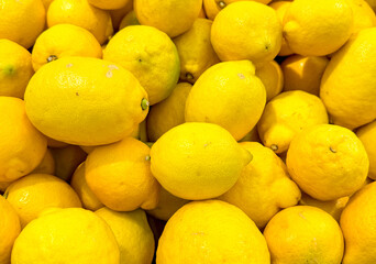Yellow lemons on a counter in a market as an abstract background. Texture