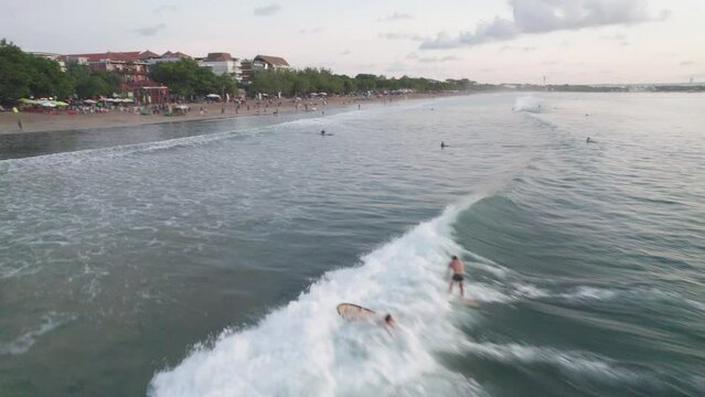 A group of people are surfing in the ocean. The water is calm and the sky is cloudy
