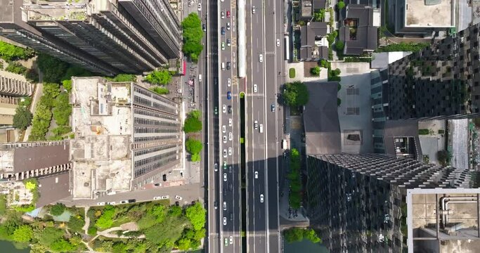 Aerial top view of Chengdu Cityscape in spring sunny day with cars driving on the road in the middle of high buildings