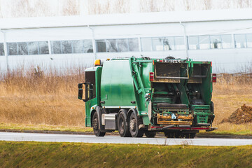 Isolated modern waste truck on the road. Sanitation industry. Municipal waste management