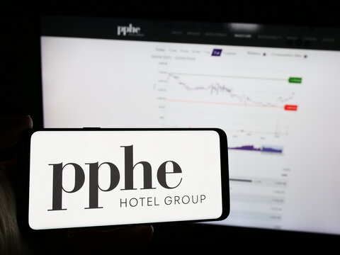 Stuttgart, Germany - 04-04-2024: Person holding mobile phone with logo of British hospitality company PPHE Hotel Group Limited in front of web page. Focus on phone display.