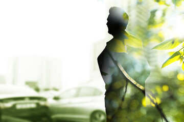 Double exposure of man and green leaves on city street