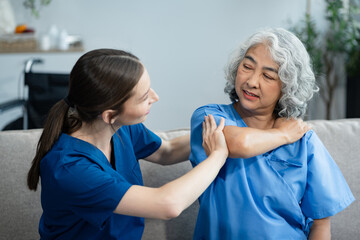 senior woman doing exercise at clinic with physiotherapist. help of a personal trainer during a...