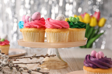 Tasty cupcakes with Easter decor on wooden table