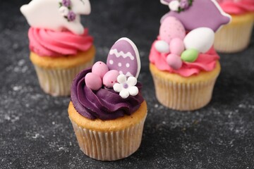 Tasty decorated Easter cupcakes on grey table, closeup