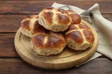 Tasty hot cross buns on wooden table