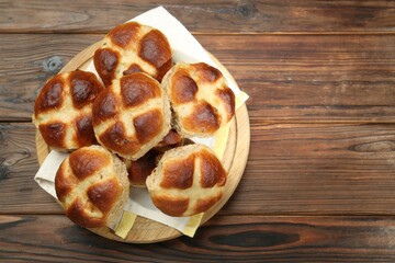 Tasty hot cross buns on wooden table, top view. Space for text